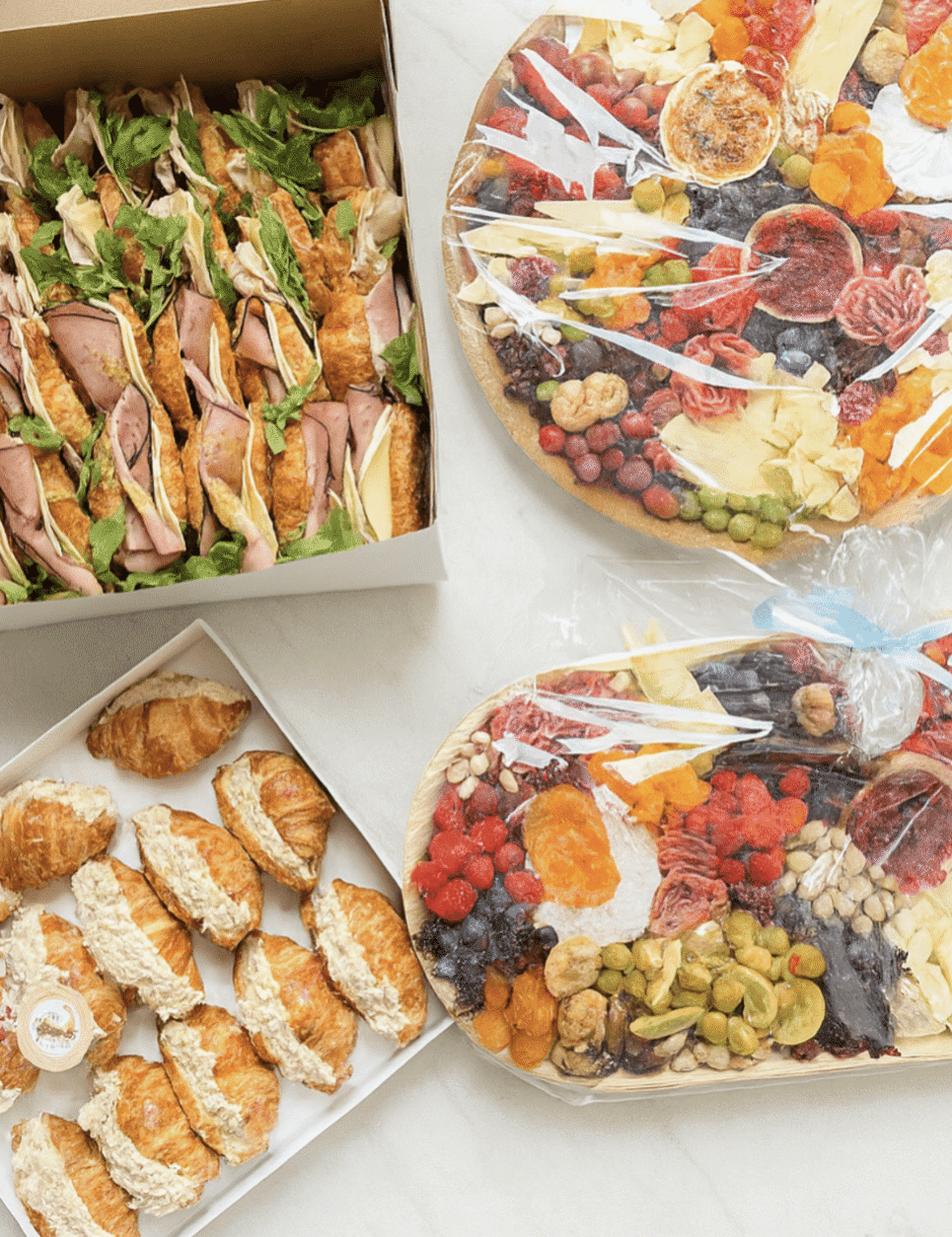Gourmet sandwich board with wraps, artisan cheeses, fruit and crackers
